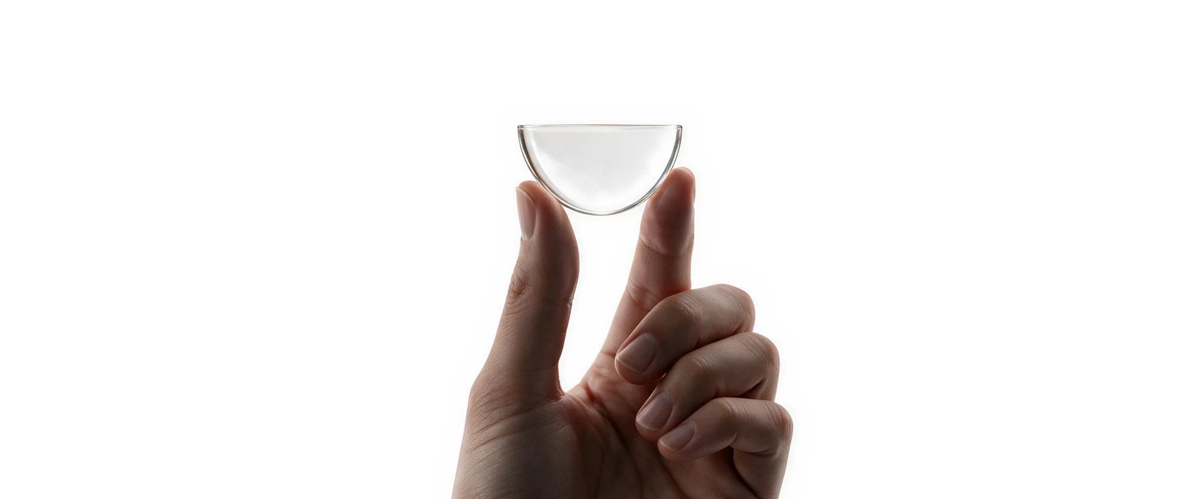 A hand holding up a clear AquaPlatin half lens